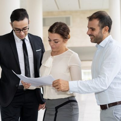 companeros-trabajo-sonrientes-que-comprueban-documentos-comerciales-reunion_1262-15204